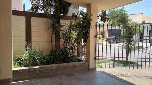 维多利亚城Casa Cd Victoria 1V的建筑前有植物的铁门