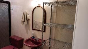 维多利亚城Casa Cd Victoria 1V的带红色水槽和镜子的浴室