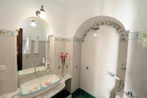 un bagno con vasca, lavandino e specchio di Tenuta Mamma Carmela ad Amalfi Altre 26 foto