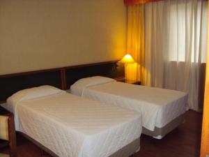 a hotel room with two beds and a window at Duomo Park Hotel in Curitiba +24 photos