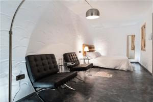 a room with two chairs and a bed at La Fonda Antigua ADULTS ONLY in Vejer de la Frontera