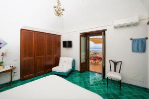 una camera da letto con un letto, una sedia e un tavolo di Tenuta Mamma Carmela ad Amalfi