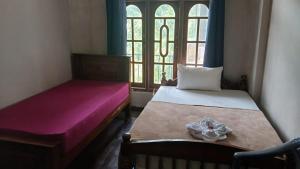 ein Schlafzimmer mit zwei Betten und einem Fenster in der Unterkunft Thumb Up Family Rest in Haputale