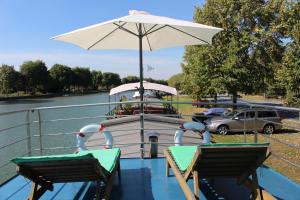a boat with an umbrella and a table and chairs at Spits-Lucie B&B in Izegem