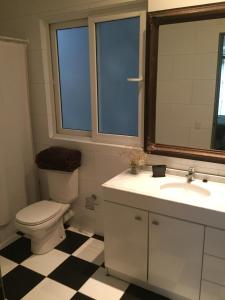 a bathroom with a toilet and a sink and a mirror at Casona Valpo in Valparaíso