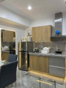eine Küche mit Küchengeräten aus Edelstahl und Holzschränken in der Unterkunft Staycation in Buli Muntinlupa in Manila