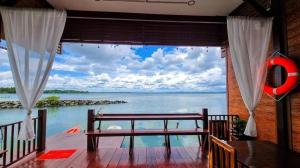 een balkon met uitzicht op het water bij 44Kohsaraihomestay 44เกาะสาหร่ายโฮมสเตย์ in Satun