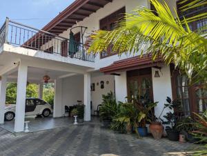 een huis met een balkon en een geparkeerde auto bij Sun Set Forest Villa in Kandy