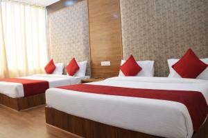 two beds in a hotel room with red pillows at Hotel Black Diamond, Patiala Chok 2 min from Zirakpur Bus Stand near Panchkula in Zirakpur