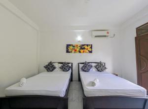 twee bedden in een kamer met witte muren bij Sun Set Forest Villa in Kandy