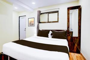 a bedroom with two beds and a window at Hotel O Metro Galaxy inn in Mumbai