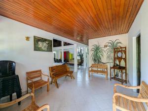 een woonkamer met houten plafonds en houten meubilair bij Sun Set Forest Villa in Kandy