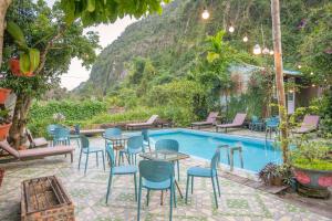 een patio met tafels en stoelen naast een zwembad bij Cat Ba Countryside Homestay in Cat Ba