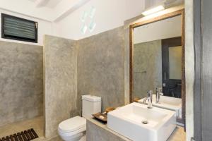 乌纳瓦图纳劳拉之家酒店的浴室里有洗手池、马桶和镜子。