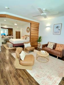 een grote woonkamer met een bed en een bank bij Sunrise by Casuarina Beach in Casuarina