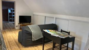 een woonkamer met een bank en een tafel bij L'estive gîte 4 étoiles in Nasbinals