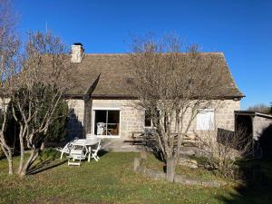 een stenen huis met een picknicktafel ervoor bij L'estive gîte 4 étoiles in Nasbinals