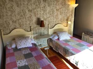 a bedroom with two beds and a table with a lamp at Casa Abuelo Pepe in Hermigua