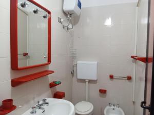 a bathroom with a sink and a toilet and a mirror at Appartamento Eucalpti Baia Verde By Nonsolomare Case Vacanze srlu in Baia Di Gallipoli