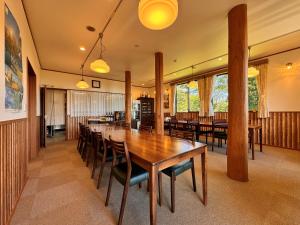 a dining room with a long table and chairs at Lodge ぷるーく in Myoko