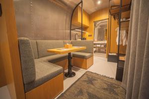 eine Ankleidekabine mit Tisch und Sofa in der Unterkunft Nomad By Sharjah Collection in Kalbā