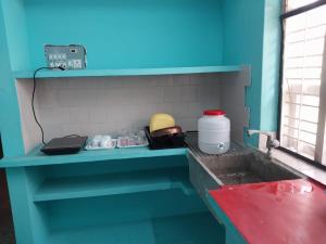een keuken met een blauwe wastafel bij Allô Gite in Pondicherry +6 foto's
