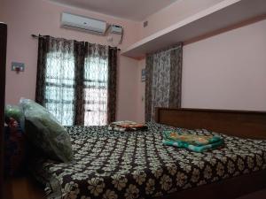 een slaapkamer met een bed met een dekbed erop bij Allô Gite in Pondicherry