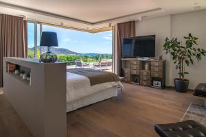 une chambre avec un lit et une grande fenêtre dans l'établissement Villa AzaiTu Suites, à Porto-Vecchio