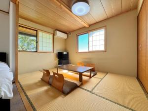 a room with a table and chairs in it at Lodge ぷるーく in Myoko