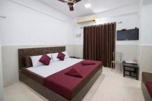 een slaapkamer met een groot bed met rode kussens bij Hotel Golden Heritage in Merces