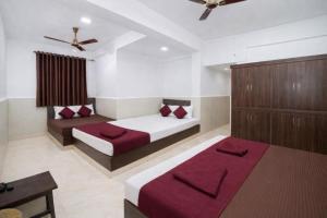 een slaapkamer met 2 bedden en rode kussens bij Hotel Golden Heritage in Merces