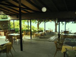 a restaurant with tables and chairs and a view of the water at guest house kalamaki beach preveza in Rizá