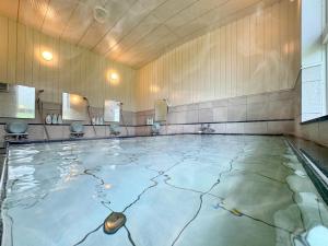 a pool of water in a room with mirrors at Lodge ぷるーく in Myoko