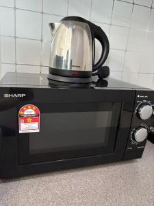 a microwave with a tea kettle on top of it at Jesselton Quay by SNUG SPACE in Kota Kinabalu +14 photos