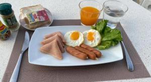 un piatto di prodotti per la colazione con uova, salsiccia e lattuga di Phala Shore Resort a Ban Phala Altre 87 foto