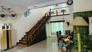 a room with a staircase and a table and a clock at Parthipuram in Thottada