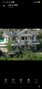 a picture of a large white house at Parthipuram in Thottada