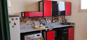 a kitchen with red cabinets and a sink at in luxor apartment in Luxor