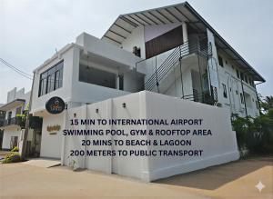 a house with a sign in front of it at Ceylon Lodge - Airport Transit Hostel in Negombo