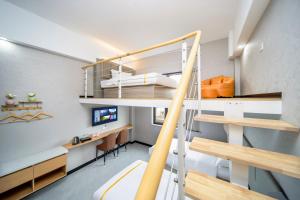 a room with a bunk bed and a desk at Shanghai Rui deng hao Hotel-Free shuttle bus to Airport and Disneyland 24x7 in Shanghai