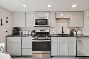 een keuken met witte kasten, een fornuis en een magnetron bij Quail Run Loft in Caldwell