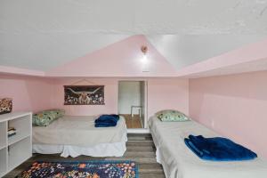 twee bedden in een kamer met roze muren bij Quail Run Loft in Caldwell