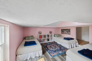 twee bedden in een kamer met roze muren bij Quail Run Loft in Caldwell