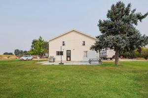 een wit huis met een boom in een veld bij Quail Run Loft in Caldwell