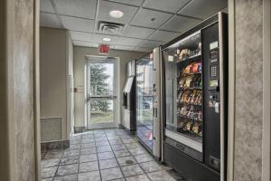 um corredor com um refrigerador de bebidas num edifício em Motel 6-London, ON - Ontario em London
