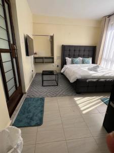 a bedroom with a bed and a tv in it at Lora's Haven Homes - Kikuyu Studio in Rungiri
