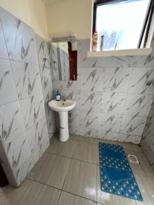 a small bathroom with a sink and a toilet at Lora's Haven Homes - Kikuyu Studio in Rungiri +8 photos