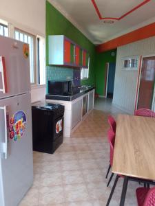 een keuken met een koelkast en een tafel met stoelen bij Sakinu Appartement in Mahajanga