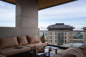 a living room with a couch and a large window at Qashqadaryo Hotel Olympic Village in Tashkent
