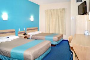 Habitación de hotel con 2 camas y TV en Motel 6-Peterborough, ON, en Peterborough